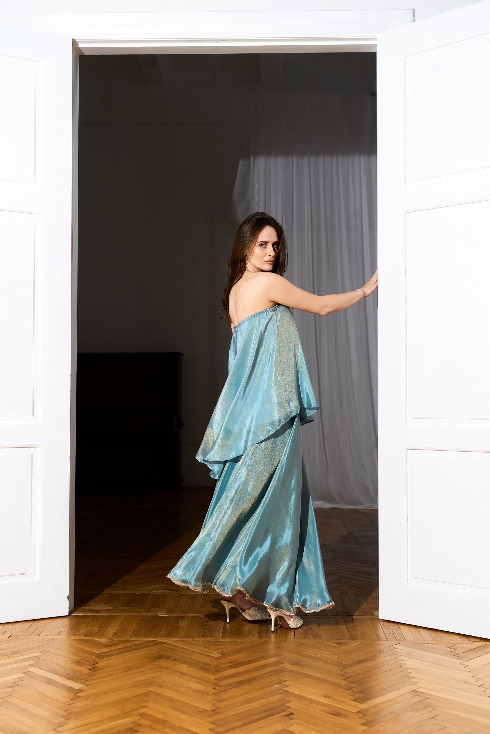 Iridescent Sky Blue organza Cloud  dress from the side in a doorway lifestyle 