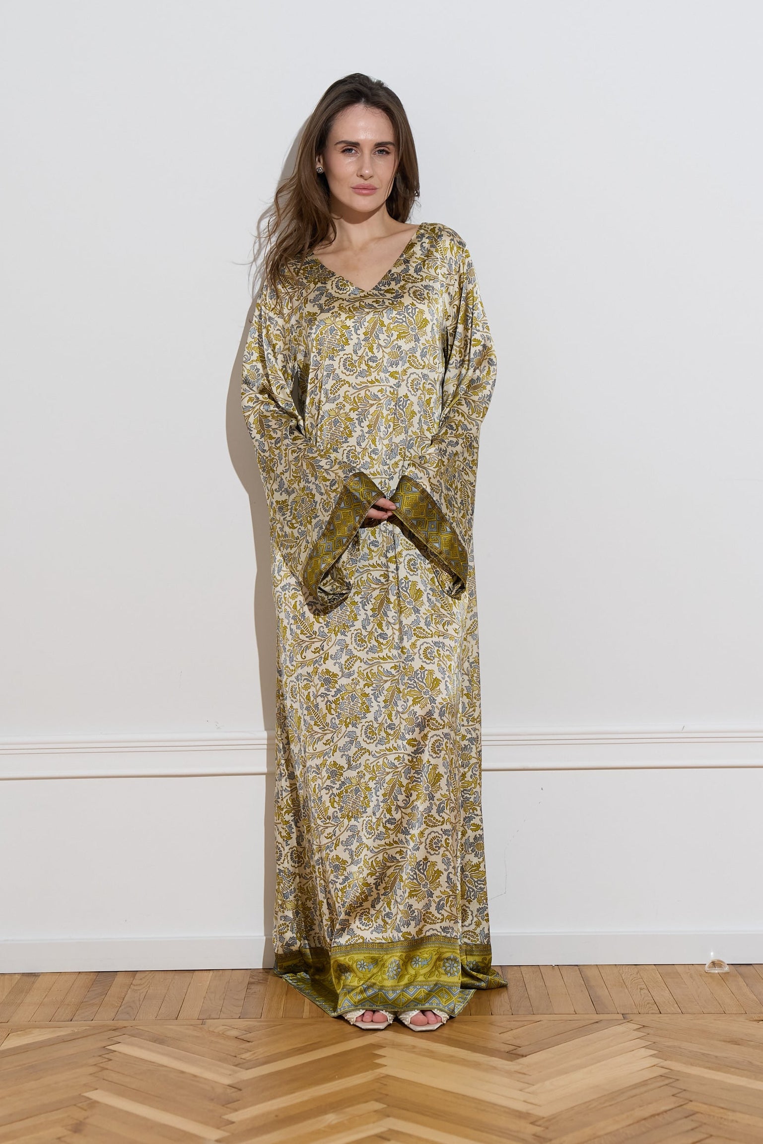 Long sleeved silk dress with a an olive floral pattern from the front 