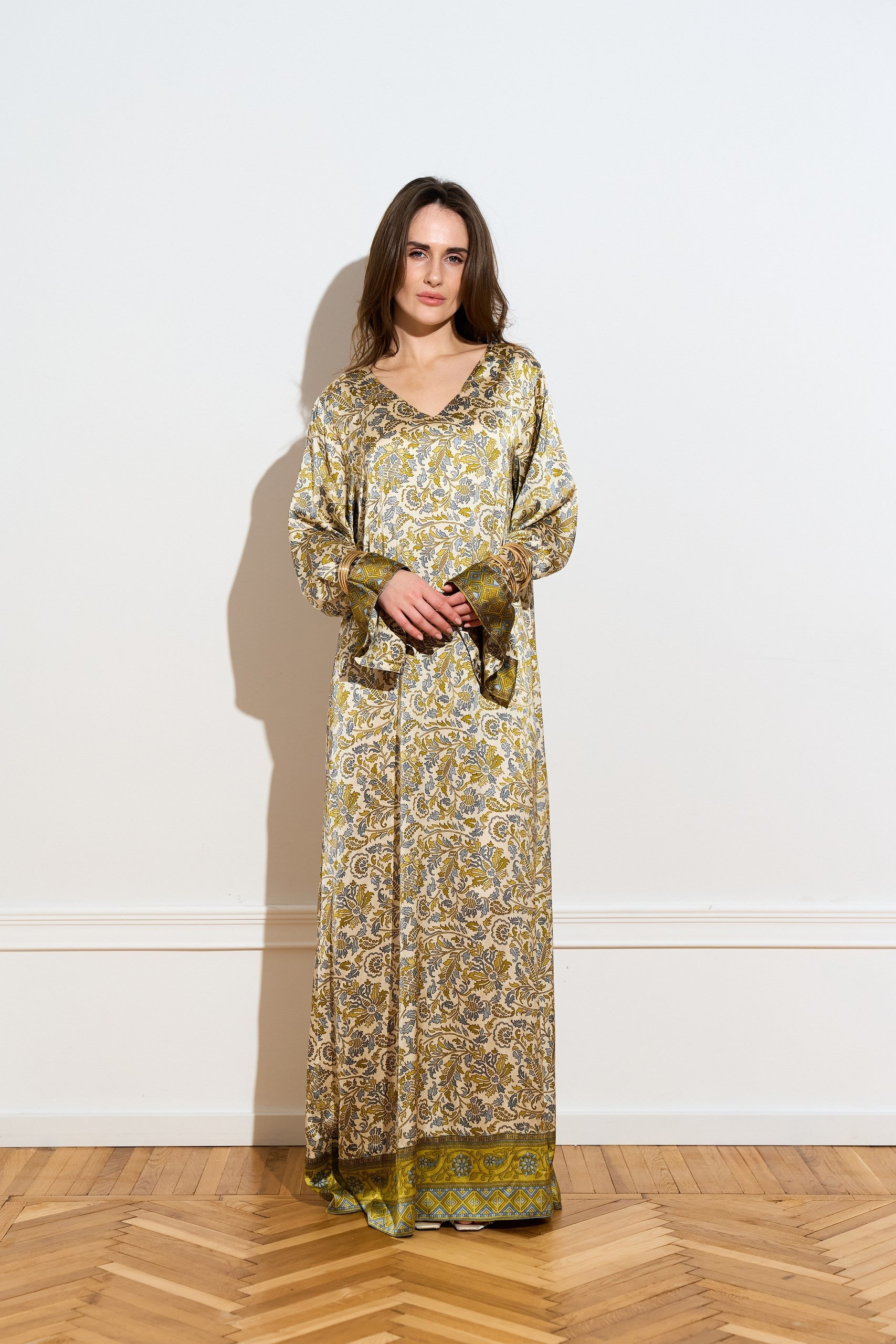 Long sleeved silk dress with a an olive floral pattern from the front with accessories 